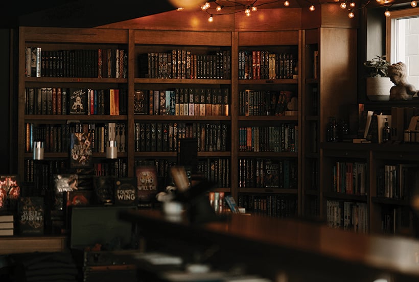 Interior of a bookstore with dark wood shelves full of books.